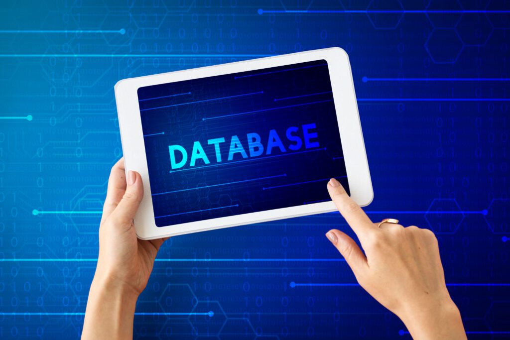 A person is holding a digital tablet displaying the word "database" on the screen